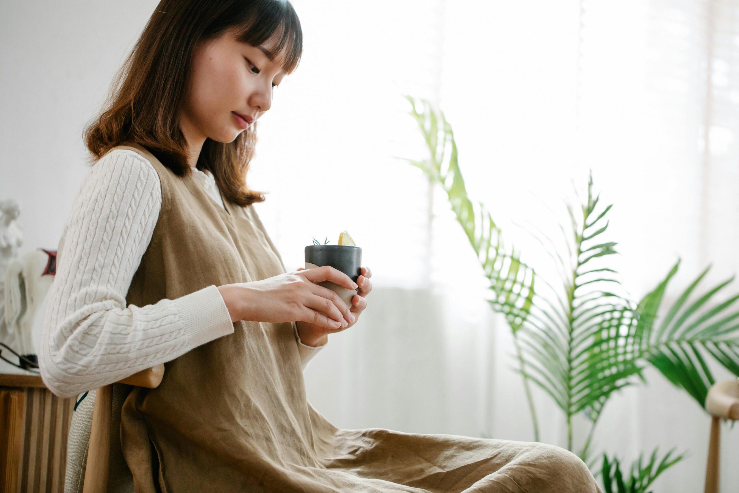 Asian woman having quiet time with tea, reflecting in a calm and intentional moment